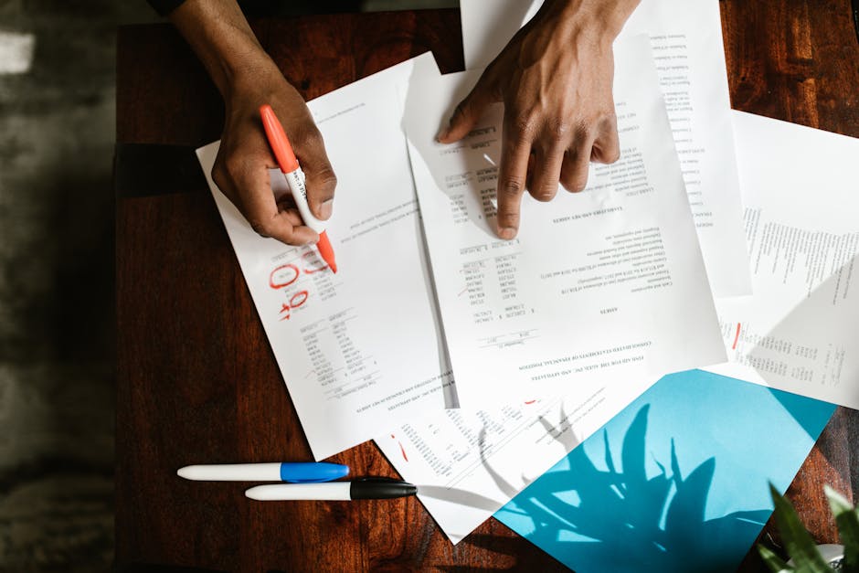 Manos revisando papeles sobre un escritorio neutro